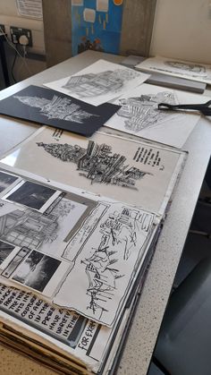 several drawings are spread out on a table