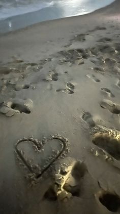 two hearts drawn in the sand at the beach