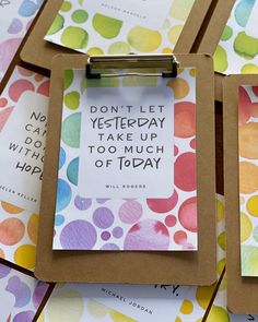 four clipboards with quotes on them sitting next to each other in front of colorful circles