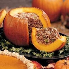 stuffed pumpkins are on a plate with leaves and other autumn decorations in the background