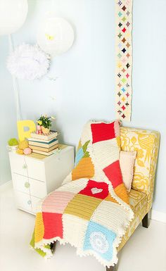 a chair with a blanket on it next to a dresser