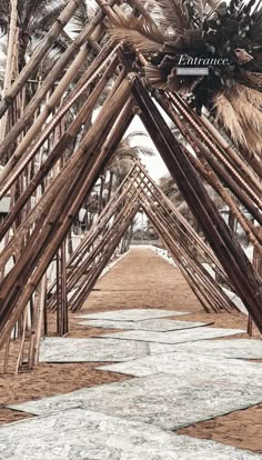 a walkway lined with wooden poles and palm trees