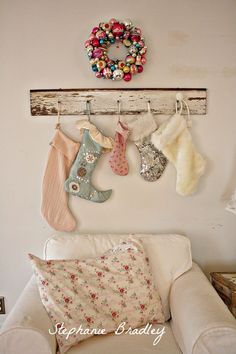 a white couch sitting next to a wall with christmas stockings hanging from it's hooks