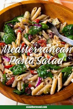 a wooden bowl filled with pasta and vegetables