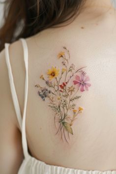 the back of a woman's shoulder with flowers painted on her left arm and chest