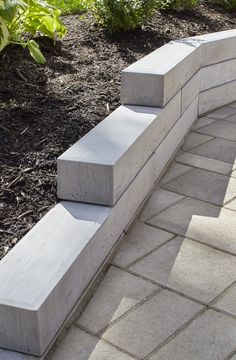 a concrete bench sitting on top of a brick walkway