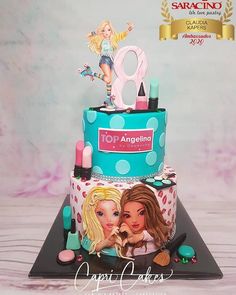 a birthday cake with two barbie dolls on top and the number one is for an angelic