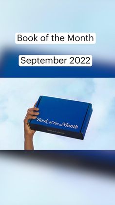 the book of the month is open to reveal it's contents and features an image of a hand holding a blue box