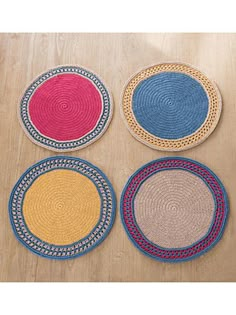 four braided placemats in various colors on a wooden table with wood flooring