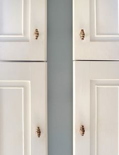 two white cupboards with brass handles and knobs