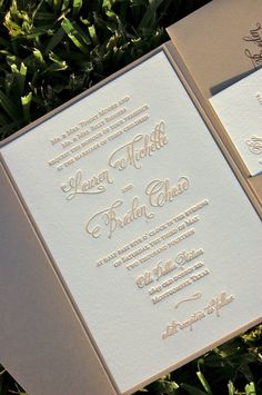 the wedding stationery is laid out on the grass