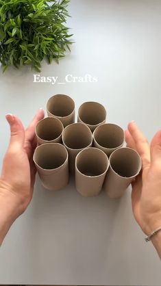 several hands are holding small cups on a table with greenery in the background that says easy crafts