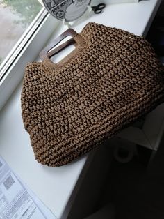 a brown purse sitting on top of a counter next to a window