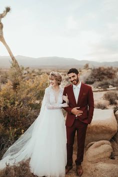 a bride and groom standing in the desert