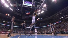 a basketball player dunks the ball in front of his team mates during a game