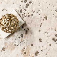 a white and gold vase sitting on top of a table next to a napkin holder