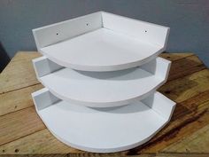 three white shelves sitting on top of a wooden table