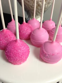 pink cake pops are on a white plate