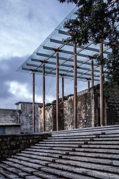 an abandoned building with stone steps leading up to it and a glass roof over the top