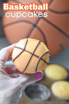 a person holding a cupcake in their hand with the words basketball cupcakes on it