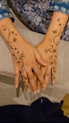 two hands with henna designs on them