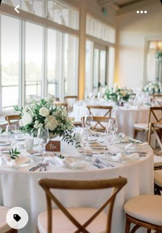 the tables are set with white flowers and place settings