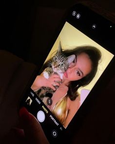 a person holding a cell phone with a cat on it's screen and an image of a woman