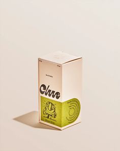 an unopened box of glue sitting on top of a white surface with a shadow