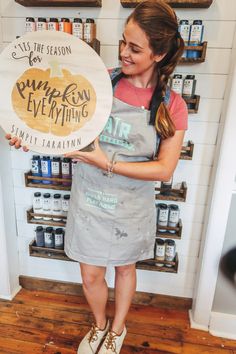 a woman holding up a sign that says pumpkin everything