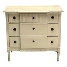 a white dresser with drawers and knobs on it's sides, against a white background