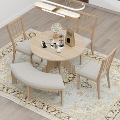 a small table with four chairs around it on a rug in the middle of a room