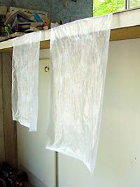 two white curtains hanging from a clothes line