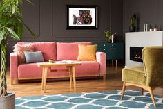 a living room filled with furniture and a rug on top of a hard wood floor