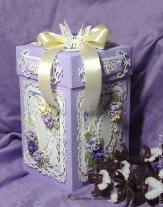 a purple box with flowers and ribbon on it