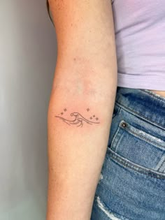 a woman's arm with a tattoo on it that has stars in the sky