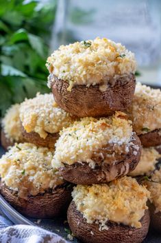 stuffed mushrooms with parmesan cheese on top are piled up in a pile and ready to be eaten