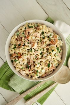 a white bowl filled with macaroni salad on top of a green napkin