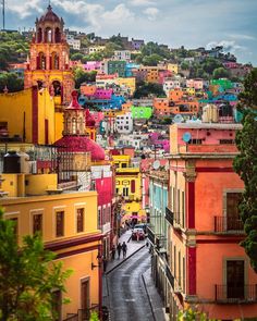 colorful buildings line the street in front of a hill