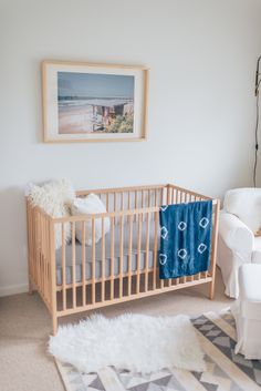 a baby's room with a crib, chair and rug