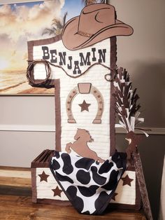 a cowboy themed birthday cake with the name ben jamin written on it and decorations