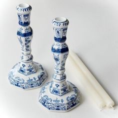 two blue and white candlesticks sitting next to each other