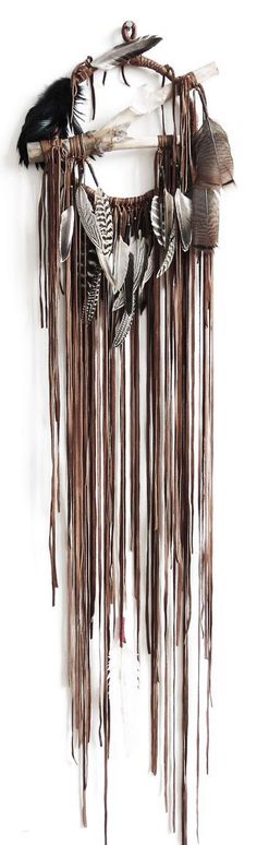 a wall hanging made out of metal and feathers