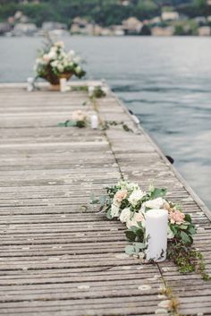 flowers and candles are lined up on the dock