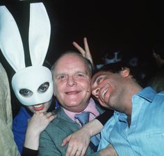 two men pose for a photo with a bunny mask on