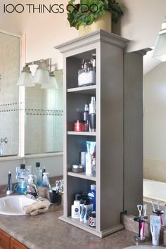 a bathroom with a sink, mirror and shelving unit in the middle of it