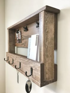 a wooden shelf with hooks and keys hanging from it's sides on the wall