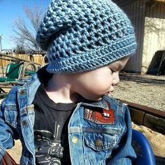 a small child wearing a blue hat sitting in a chair