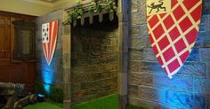 an indoor area with artificial grass and fake stone walls, decorated with flags and decorations