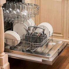 an open dishwasher in a kitchen with white dishes and silverware on the trays