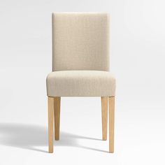 an upholstered chair with wooden legs and a beige fabric seat cover on a white background